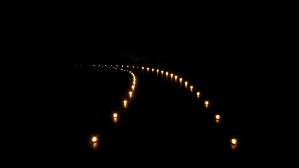 A path marked by points of gold light curving through the dark